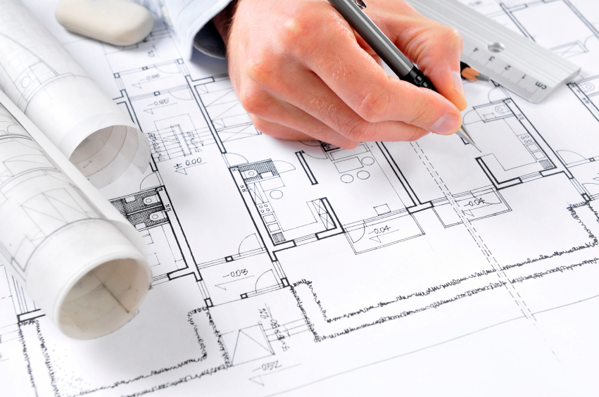 Architectural plans laid out on a desk while being worked on.