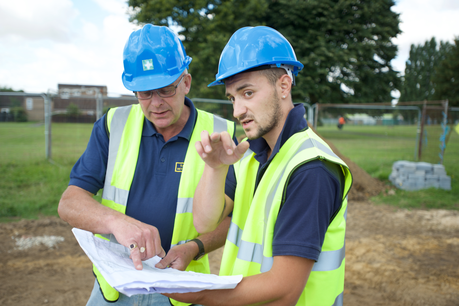 Builders on site inspecting architectural plans