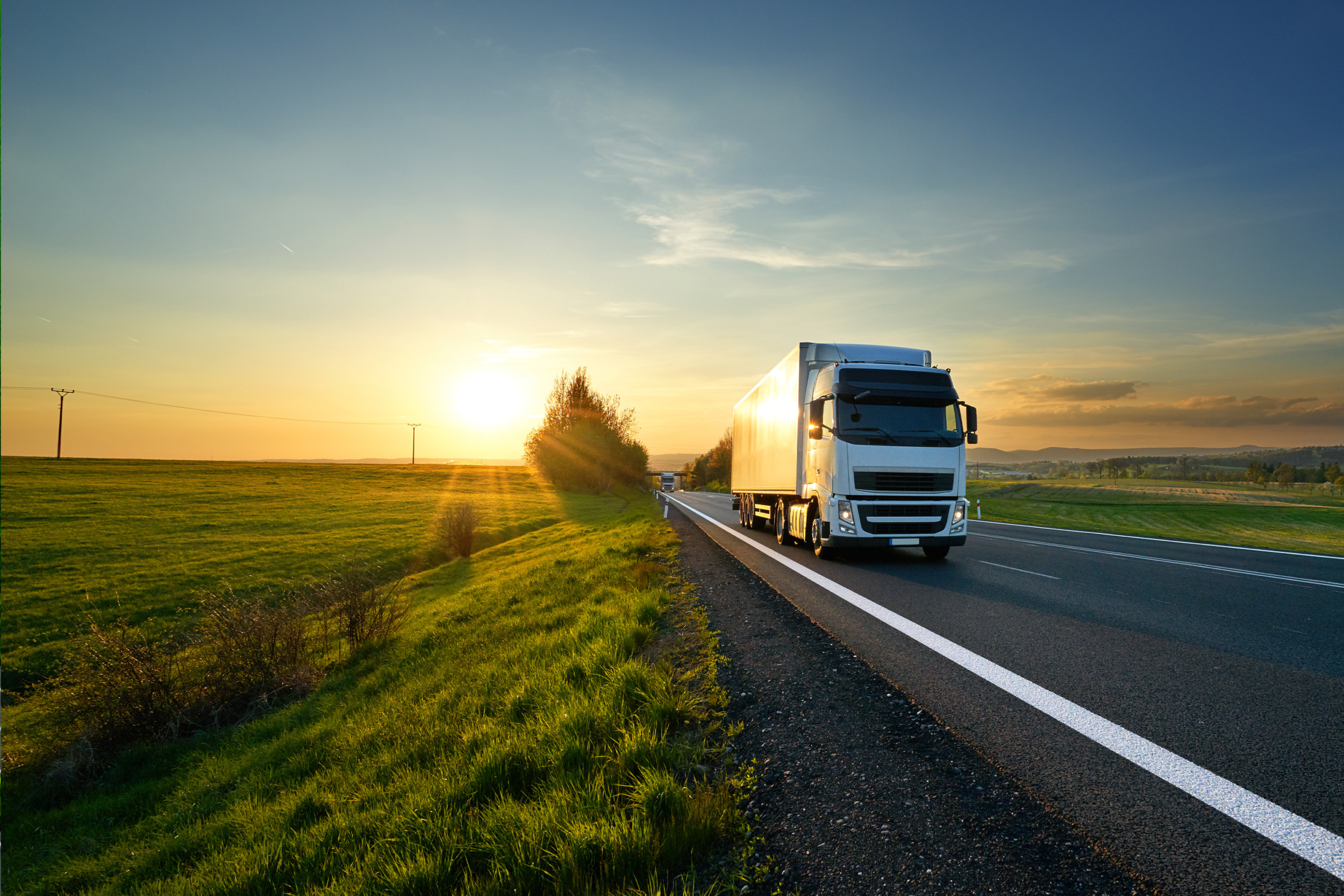 truck driving on road at sun rise