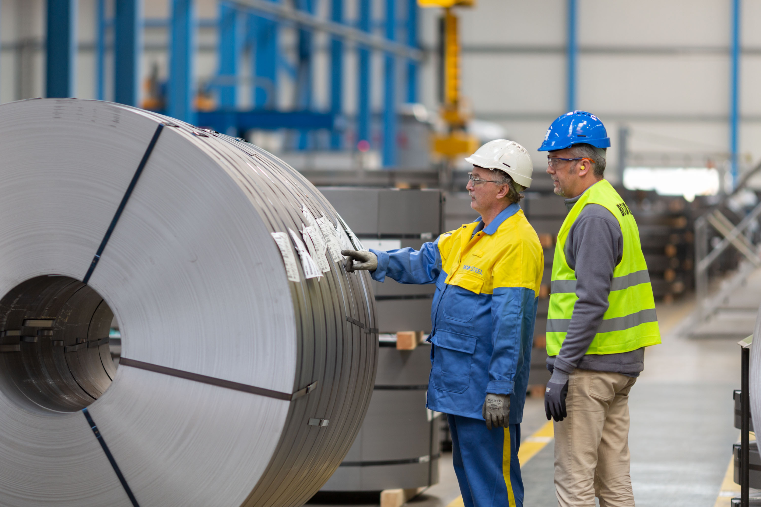 tata steel colleague standing next to coil of steel