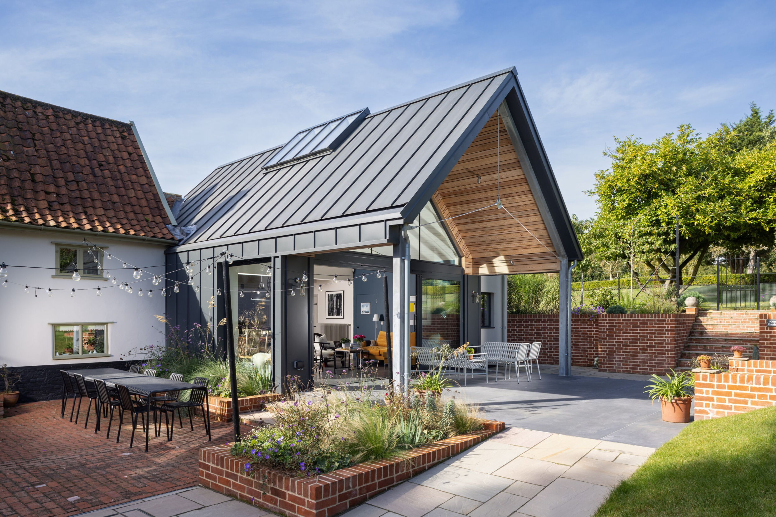 Modern home extension using standing seam metal roof and wall fascia